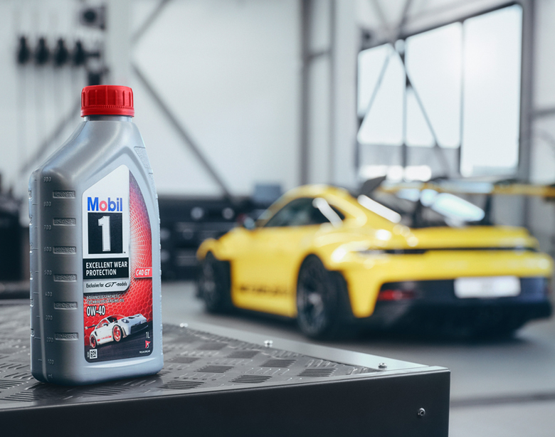 Aceite Mobil 1 delante de un Porsche amarillo en el taller