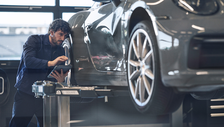 Técnico de Porsche Service revisando un Porsche en el taller