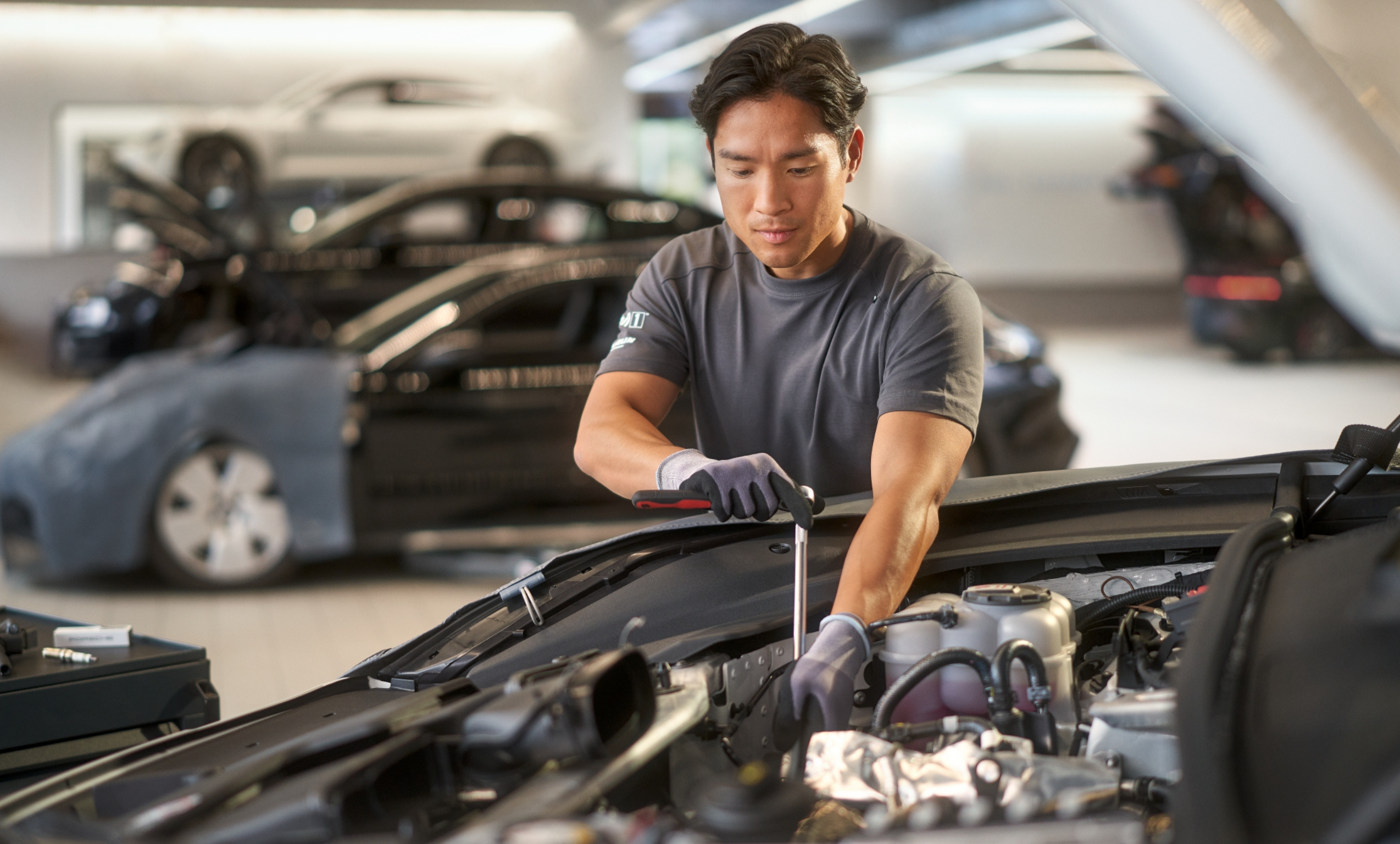 Técnico de Porsche Service revisando el motor de un Porsche en el taller