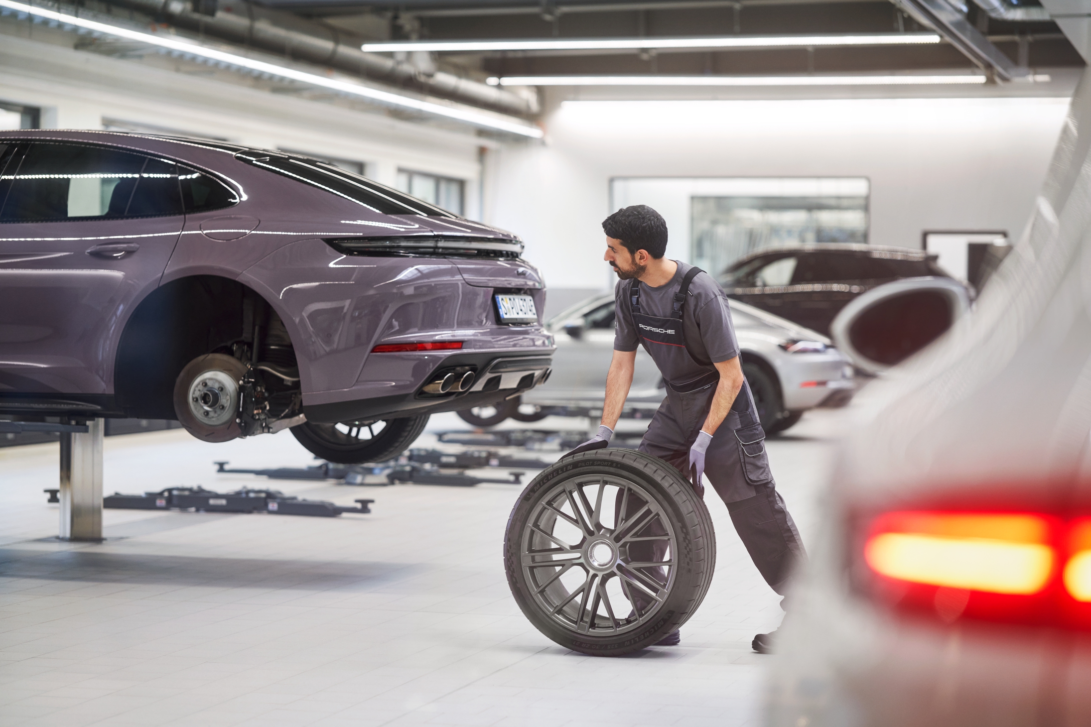 Técnico de Porsche Service cambiando una rueda en el taller